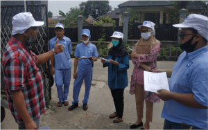 Sekelompok orang berkumpul di luar gedung, terlihat sedang berdiskusi dan mempersiapkan dokumen, dengan satu orang memberi tanda setuju.